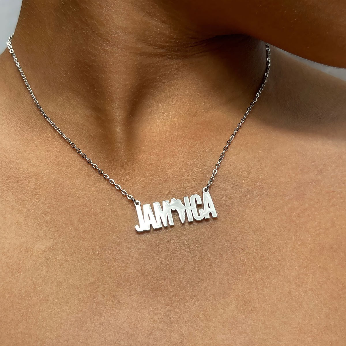 Silver Jamaica and Africa inspired necklace worn on skin